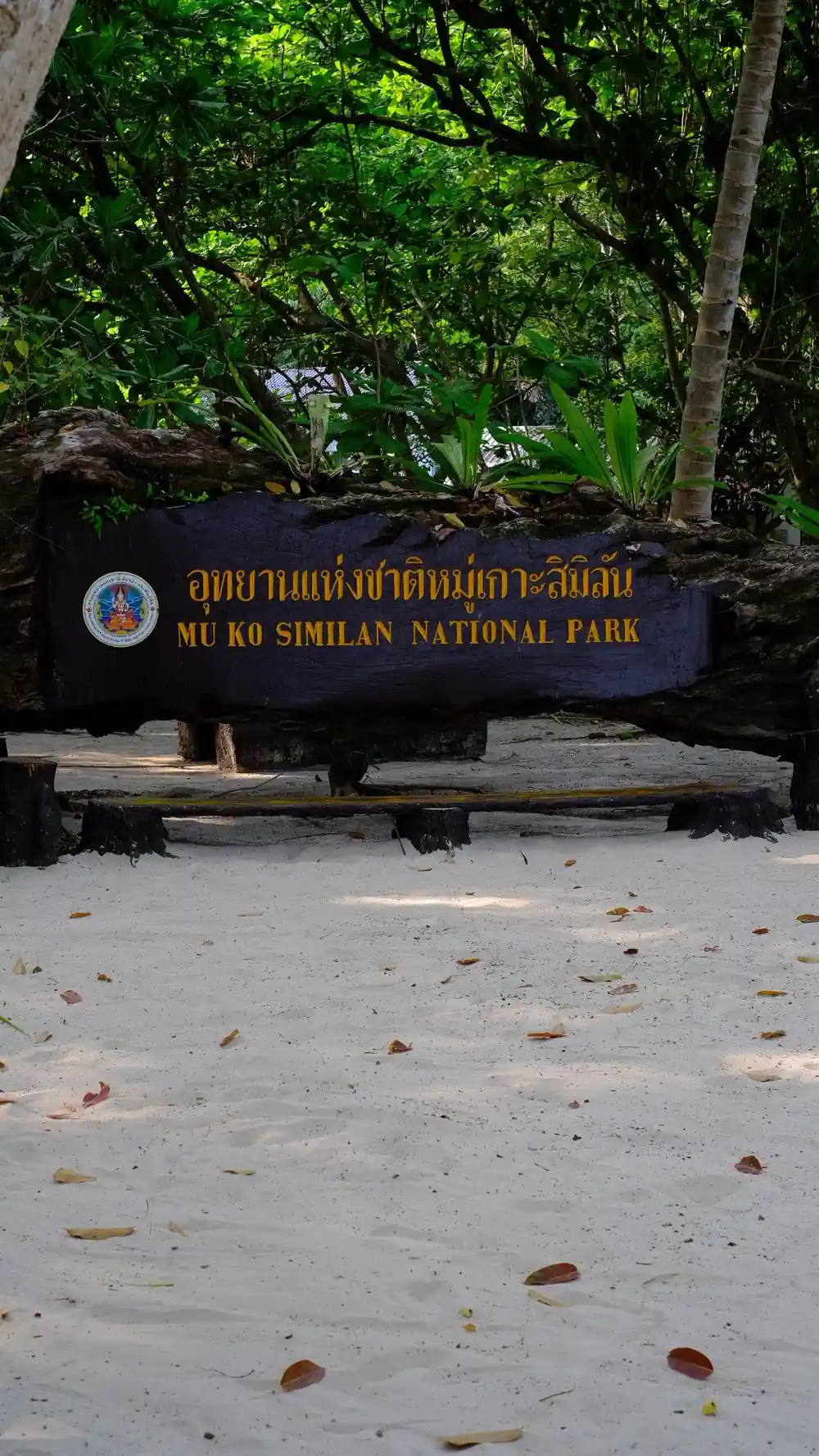 Dark blue sign for Mu Ko Similan National Park under trees