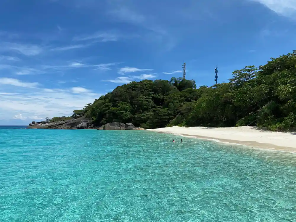 Granite boulders frame white sand beach and turquoise sea