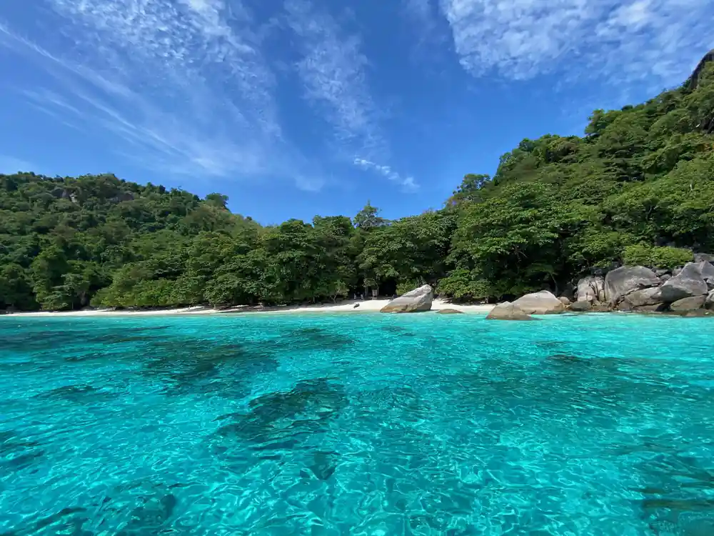 Granite boulders and white beach meet turquoise lagoon