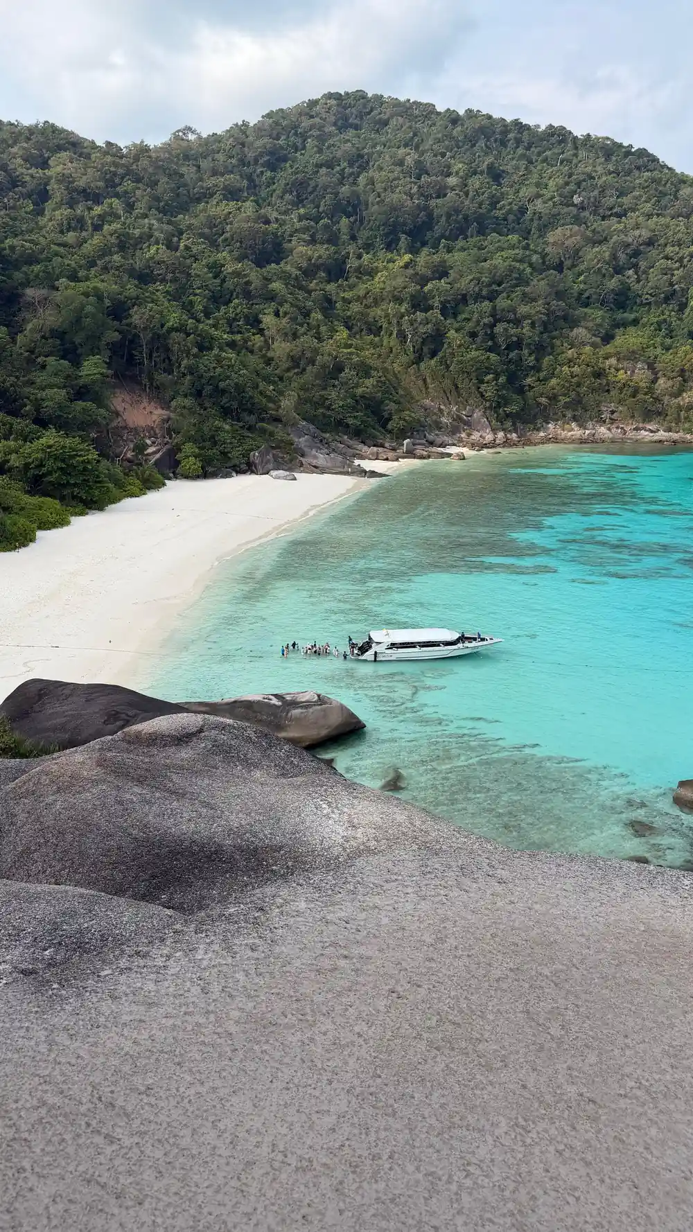 Large granite boulders on white sand beach with turquoise water