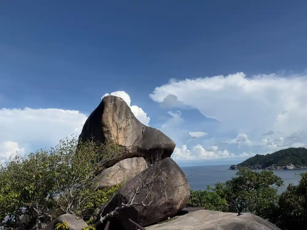 Large stacked granite boulders against sky and distant islands