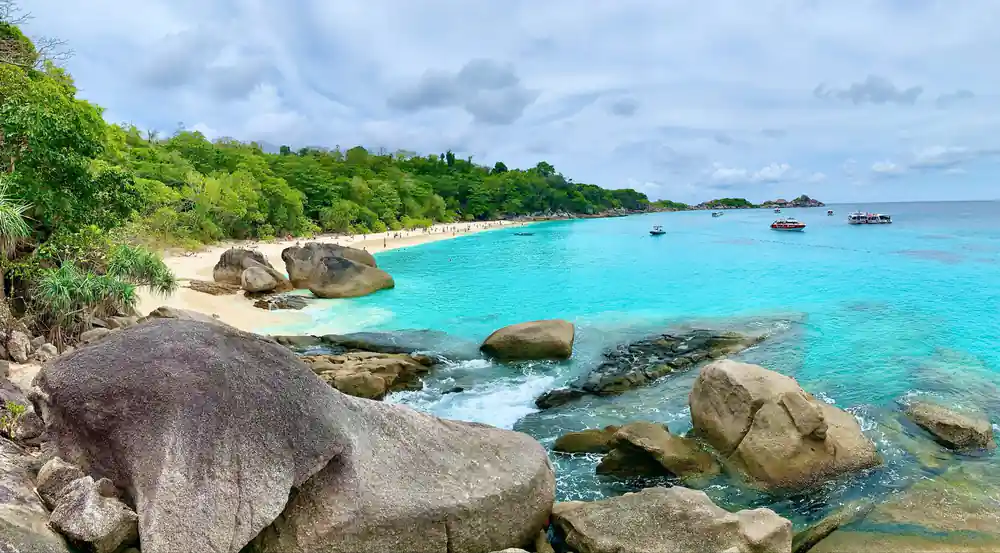 Turquoise water with granite boulders and white sandy beach