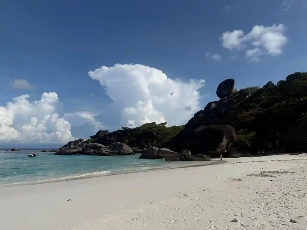 White sand beach with large granite rock formations in water